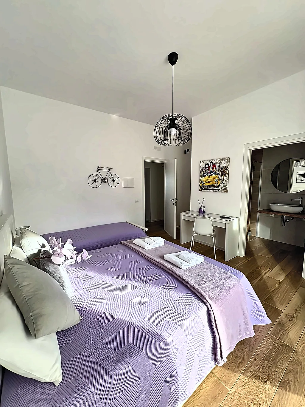 La camera Betulla: letto matrimoniale, scrivania e porta aperta sul bagno