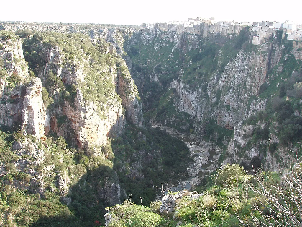 Il borgo antico di Castellaneta a strapiombo sulla Gravina Grande, tra pareti di roccia e vegetazione
