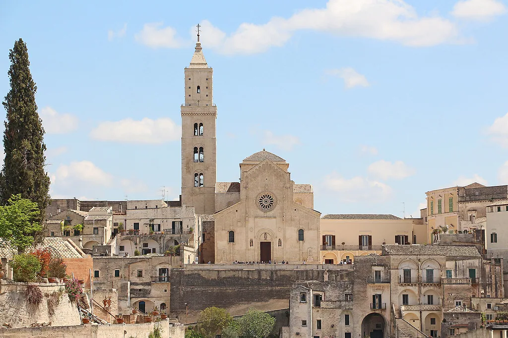 La Cattedrale romanica di Matera, con il campanile e il rosone, sopra le case dei Sassi
