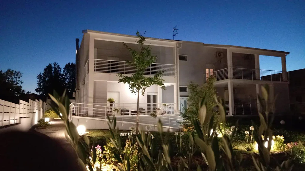 Facciata di L'Ulivo D'oro al crepuscolo, con il giardino illuminato
