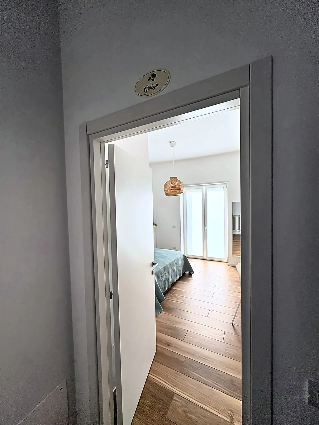 La porta della camera Ginkgo con la targhetta, aperta sulla camera luminosa