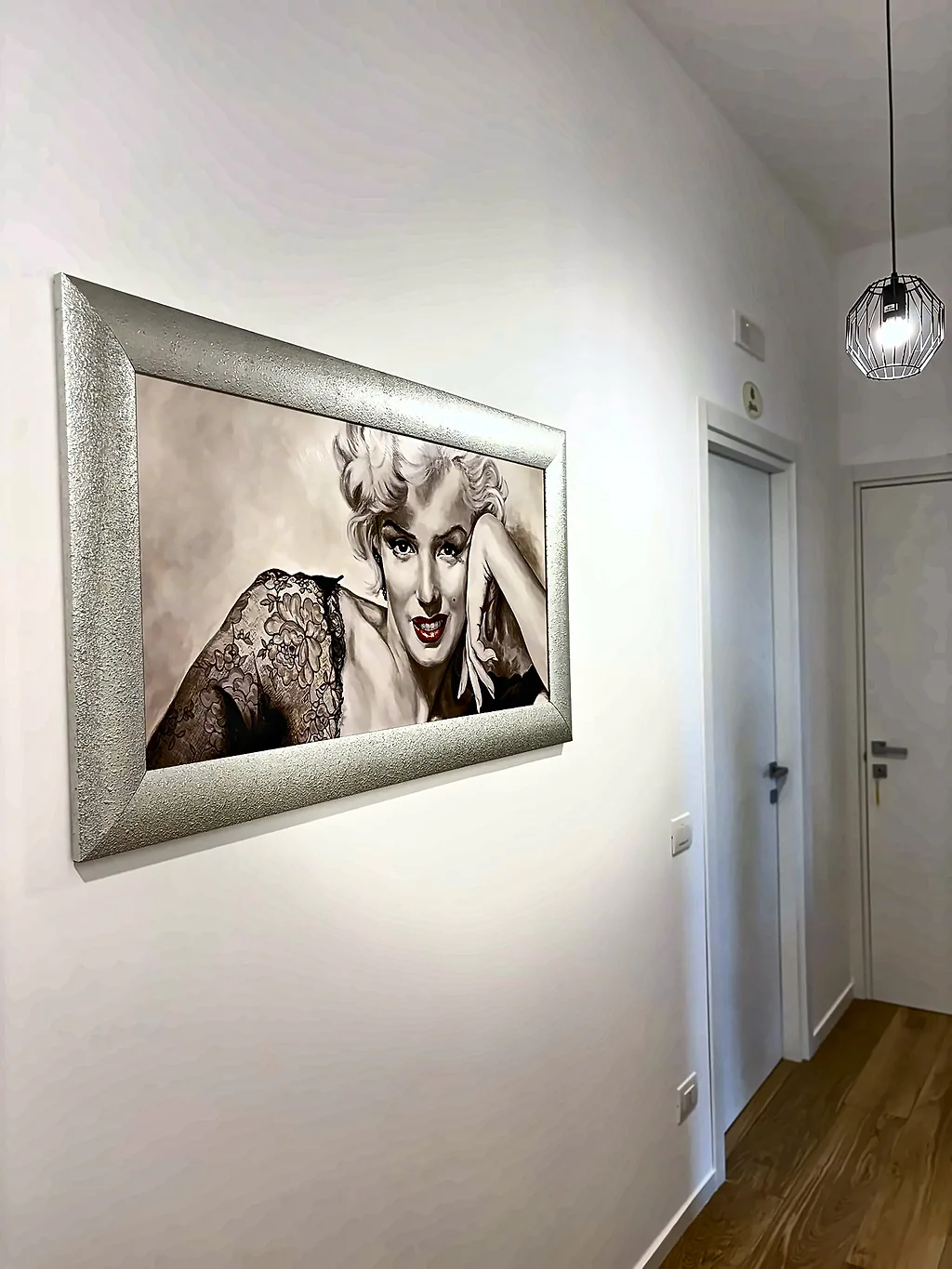 Il corridoio con un grande ritratto di Marilyn Monroe in cornice argentata
