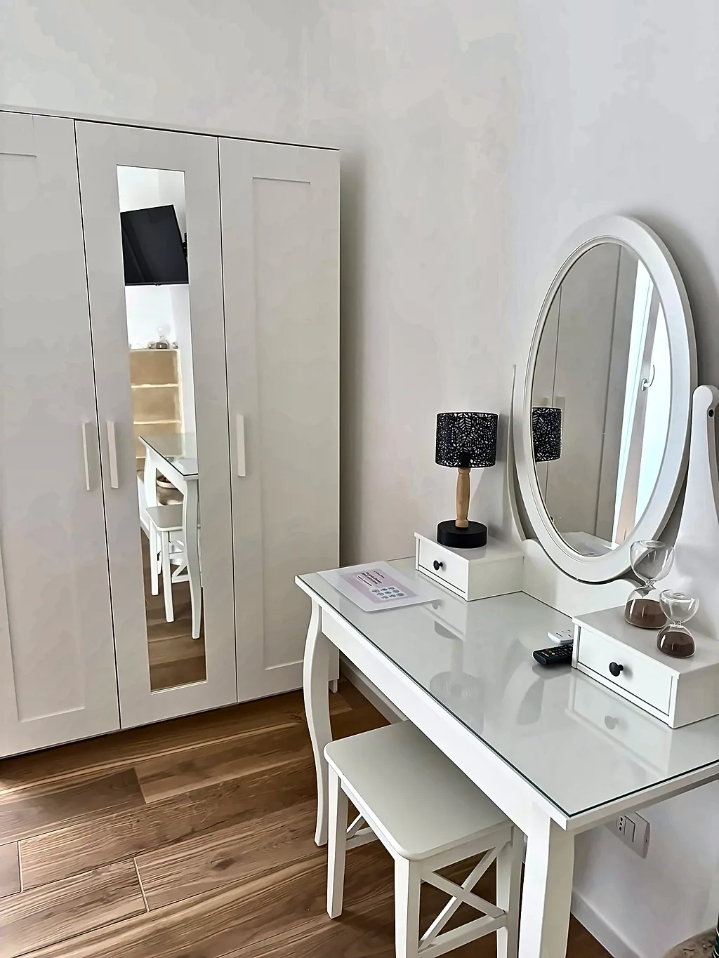 L'armadio bianco con specchio e la toeletta con lampada e specchio ovale